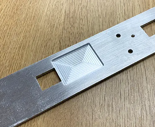 Bearbeitete Aussparung in der Rückseite einer Frontplatte zur Lokalisierung einer elektronischen Komponente.